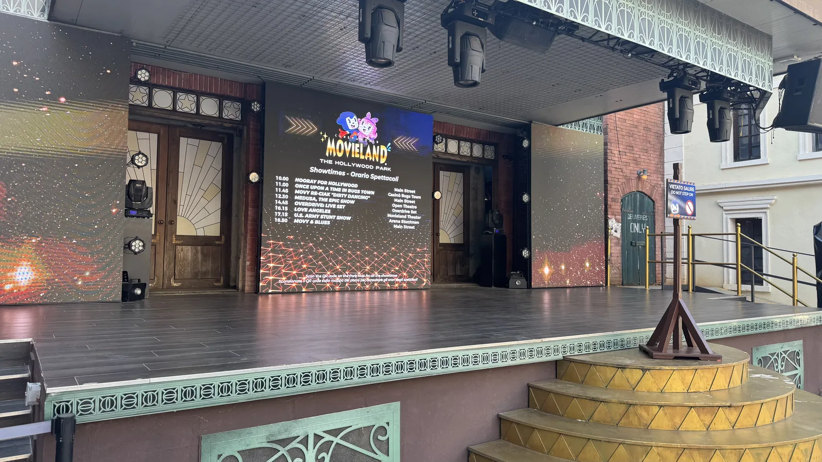 Freilichtbühne im Movieland Park mit LED-Wand, auf der die Showzeiten stehen, davor eine leere Bühnenfläche mit Scheinwerfern