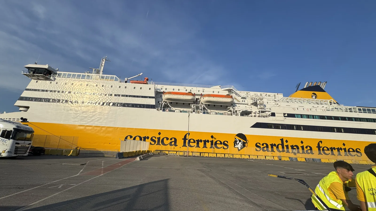 Gelbe Fähre von Corsica Ferries im Hafen, davor wartende Fahrzeuge zur Verladung auf die Korsika-Überfahrt