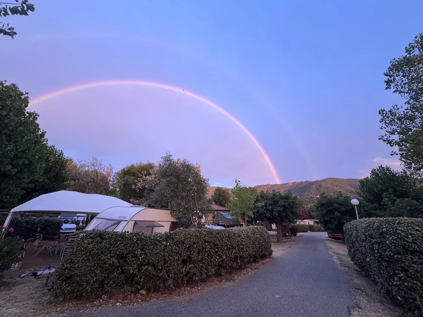 Doppelter Regenbogen über den Stellplätzen am Camping A Marina am Abend