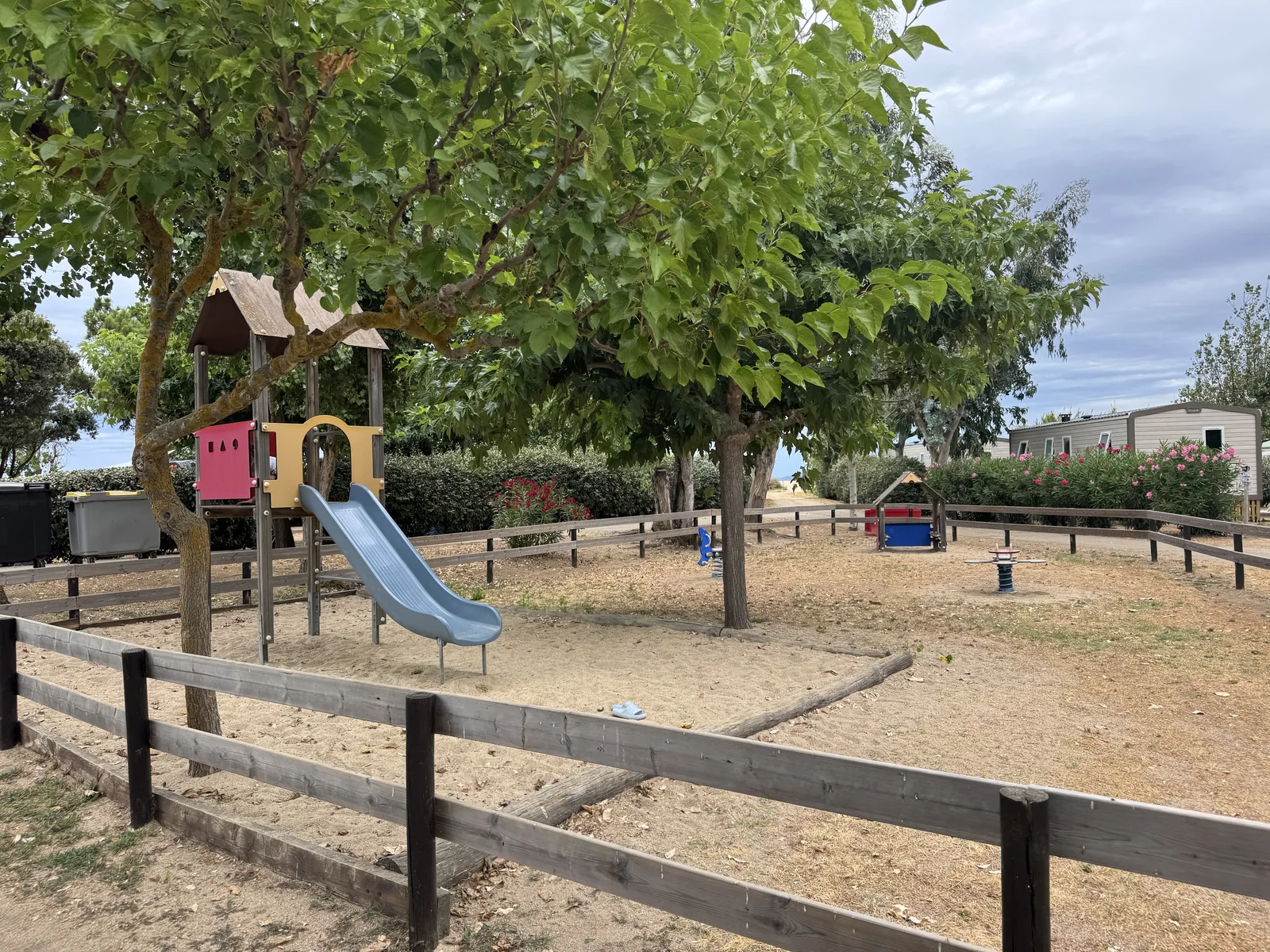 Eingezäunter Spielplatz mit Rutsche am Camping A Marina
