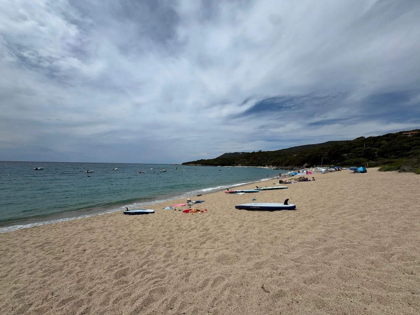 Breiter Sandstrand mit Liegen und ruhigem türkisem Wasser am Camping Chez Antoine