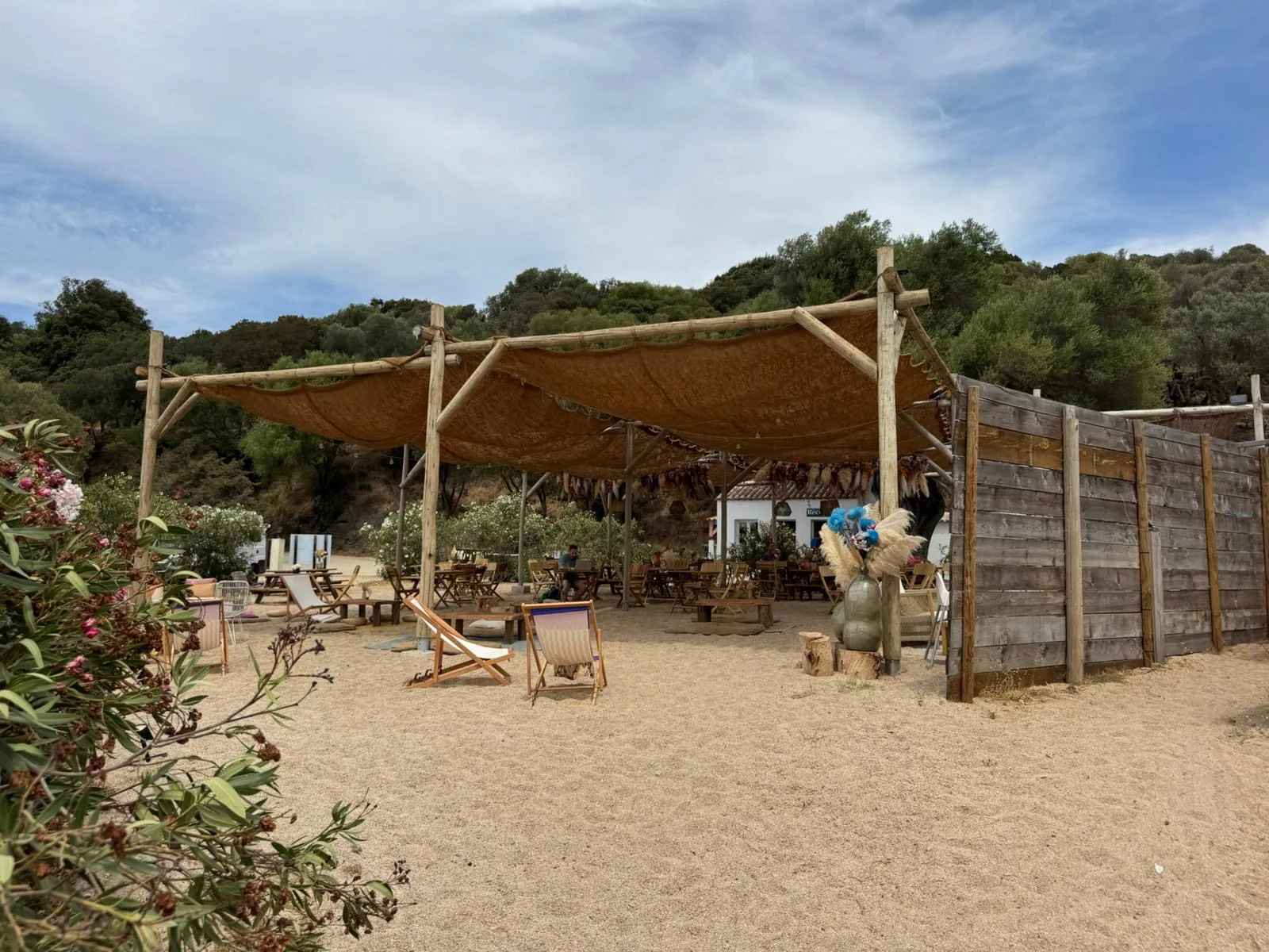Strandbar mit Schilfdach und Liegestühlen im Sand am Camping Chez Antoine