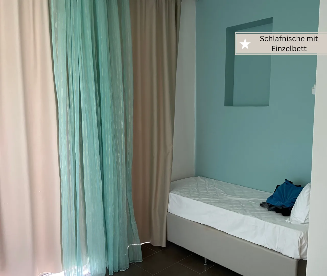 Familienzimmer mit zwei Einzelbetten hinter einer dünnen Abtrennung