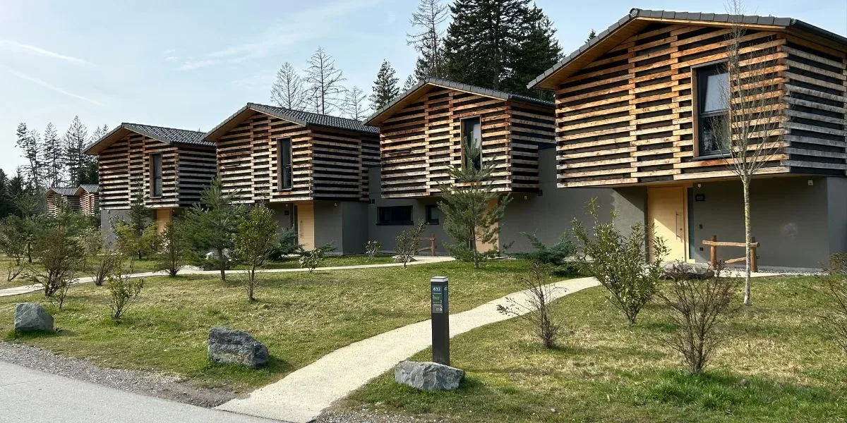 Ferienhäuser im Center Parcs Park Allgäu zwischen Wiesen und Bäumen