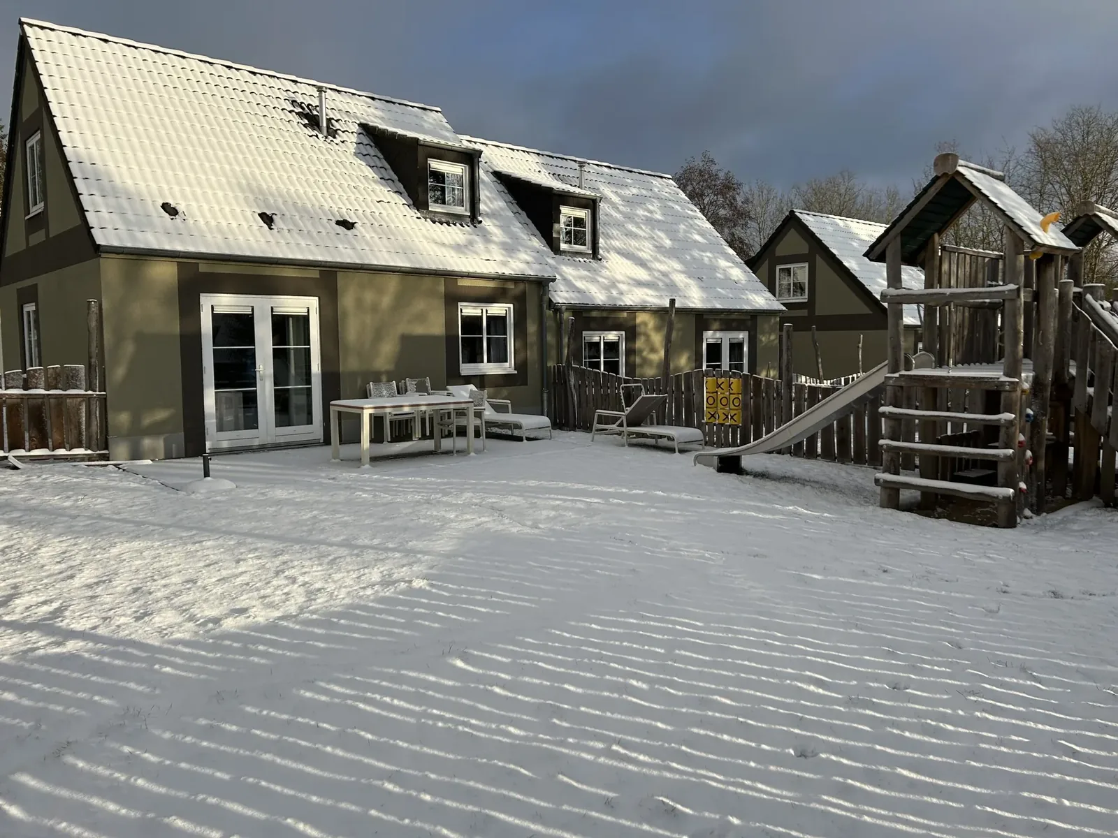 Naturwunder-Ferienhäuser im Center Parcs Eifel mit Terrasse und Spielgerät im Schnee
