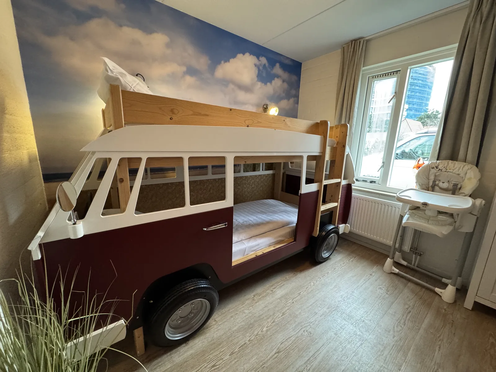 Kinderzimmer der Beach Chilla mit Hochbett in Form eines VW-Bullis, Wolkentapete und Kinderhochstuhl