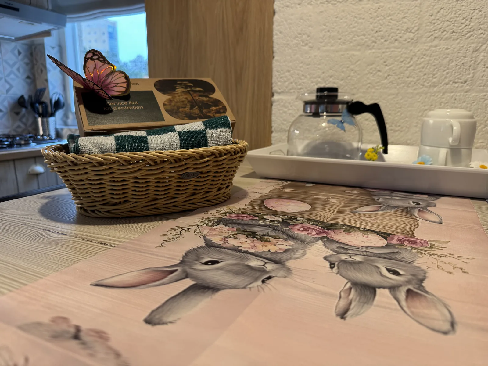 Korb mit Tee- und Kaffeezubehör auf dem Esstisch der Beach Chilla, die Tischdecke zeigt ein Hasenmotiv