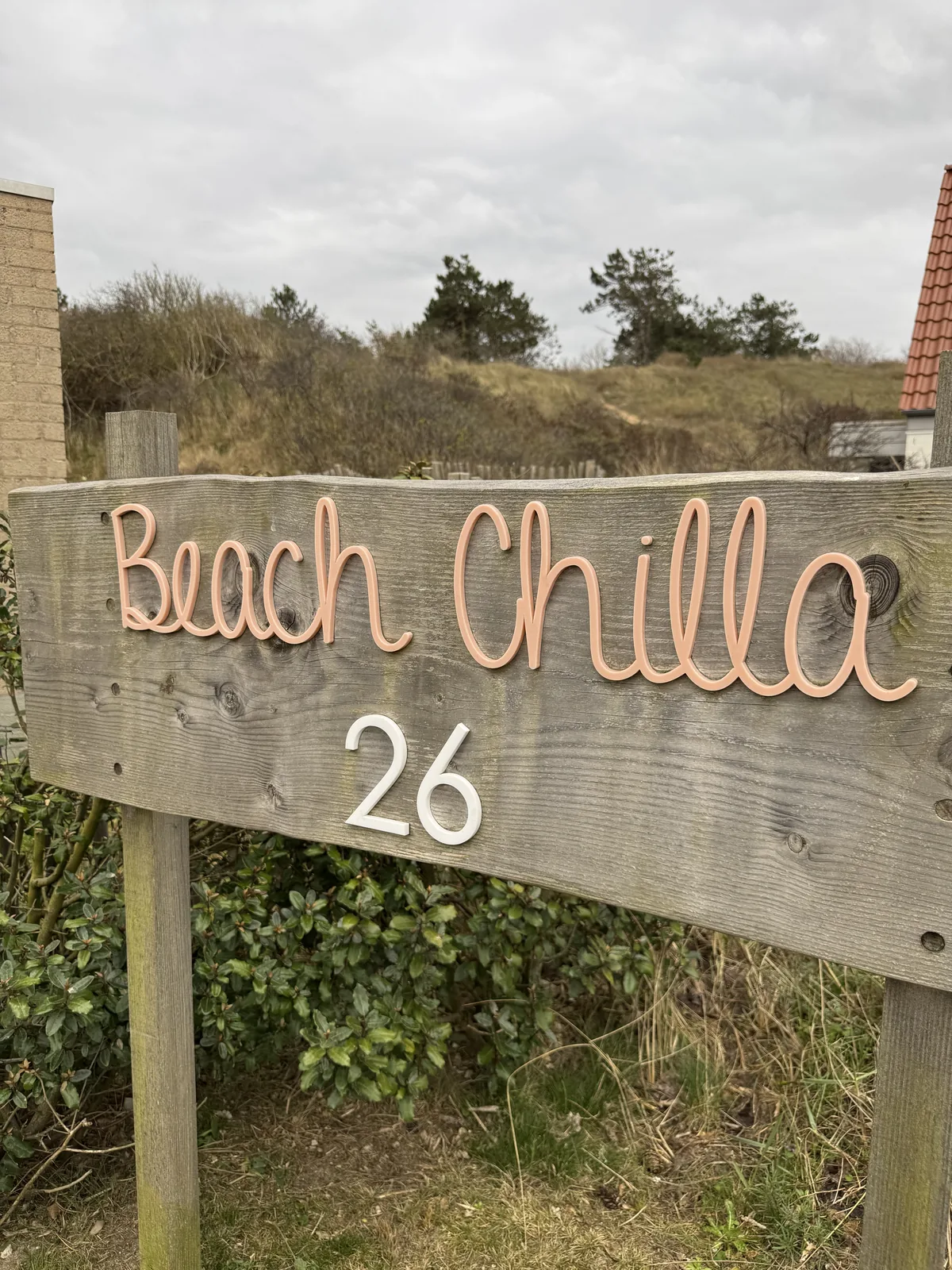 Hölzernes Hausschild mit der Aufschrift Beach Chilla 26 im Dünengelände des Center Parcs Park Zandvoort
