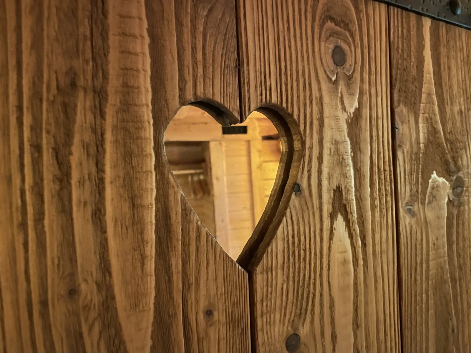 Herzförmiger Ausschnitt in einer Holztür im Baumhaus