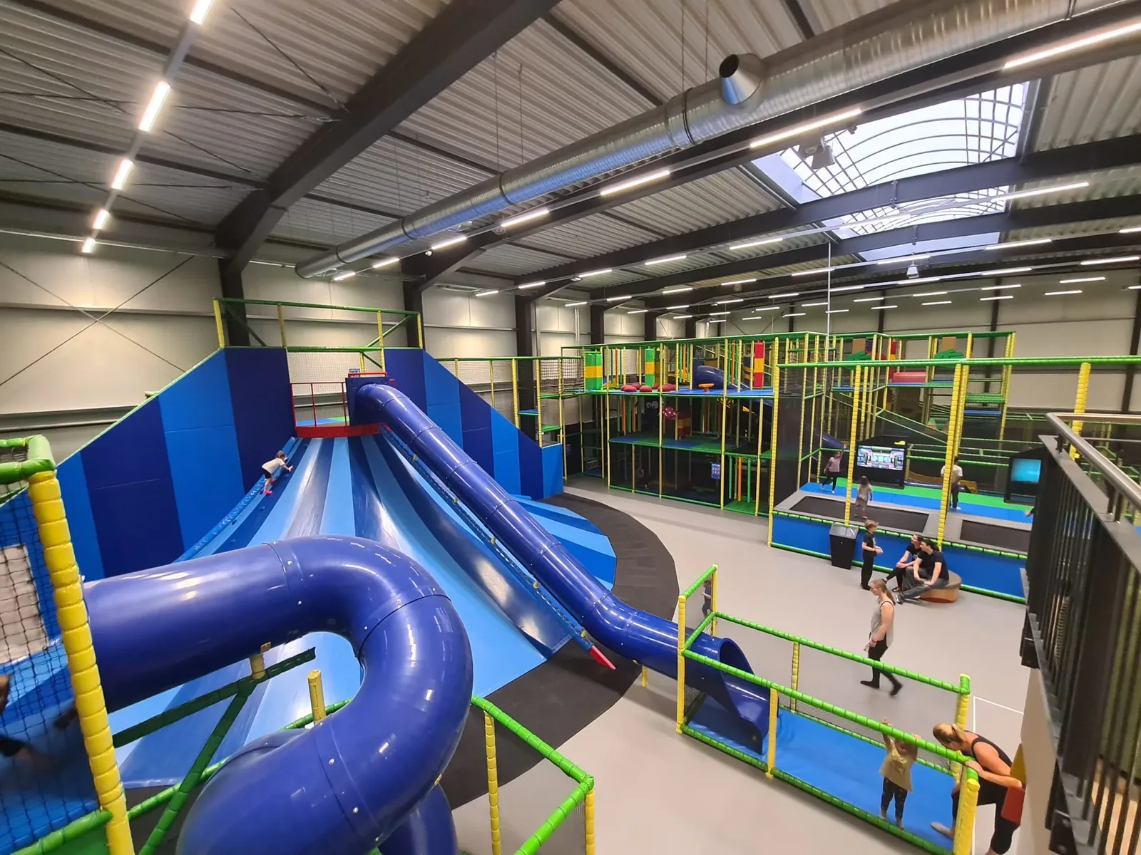 Blick von oben über die Rutschen, das Klettergerüst und den Trampolinbereich in Lykkeland