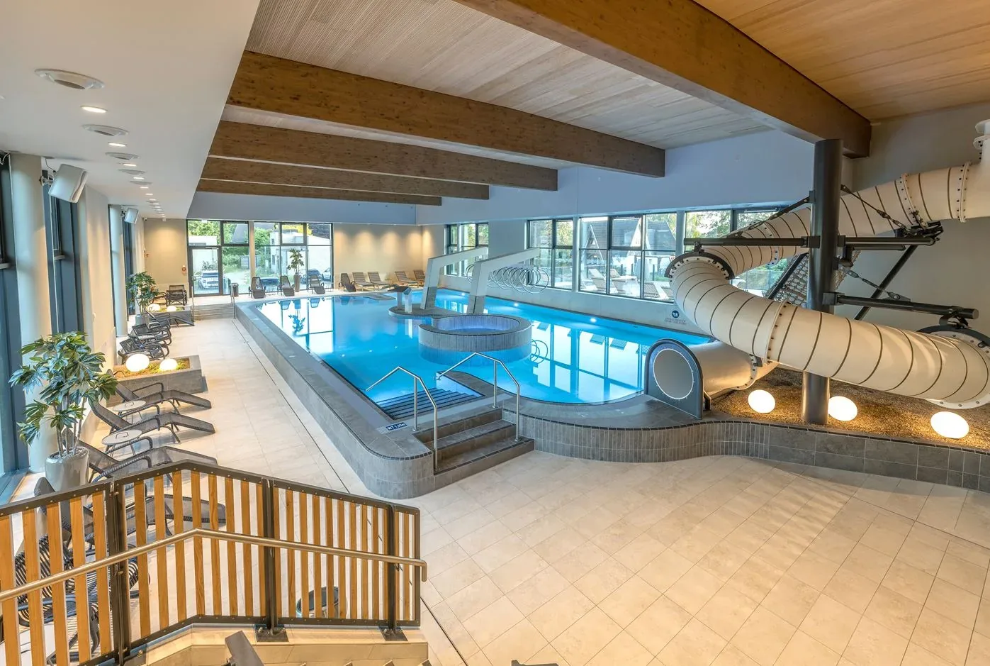 Das kleine Hallenbad im Marissa Ferienpark mit Becken, Whirlpool und weißer Röhrenrutsche