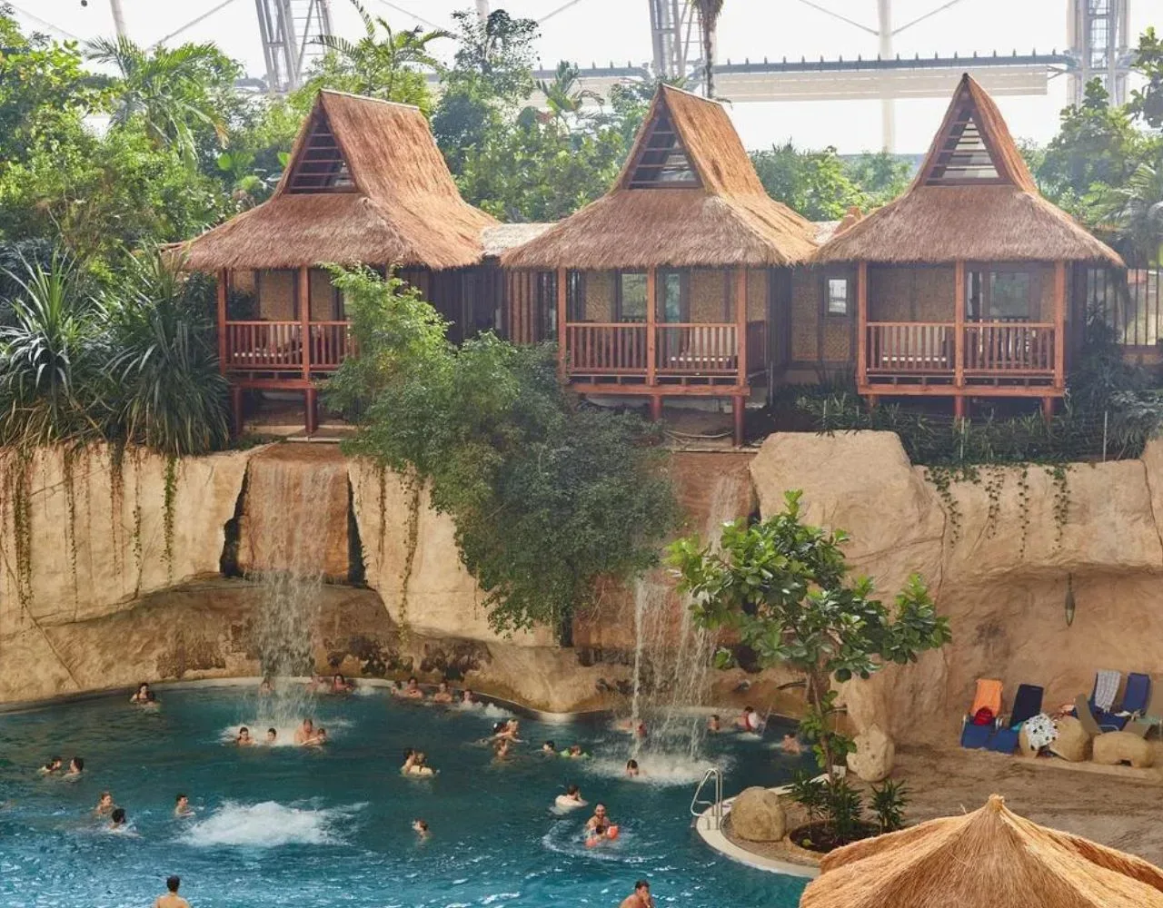 Suiten mit Reetdach über dem Wasserfall der Lagune im Tropical Islands