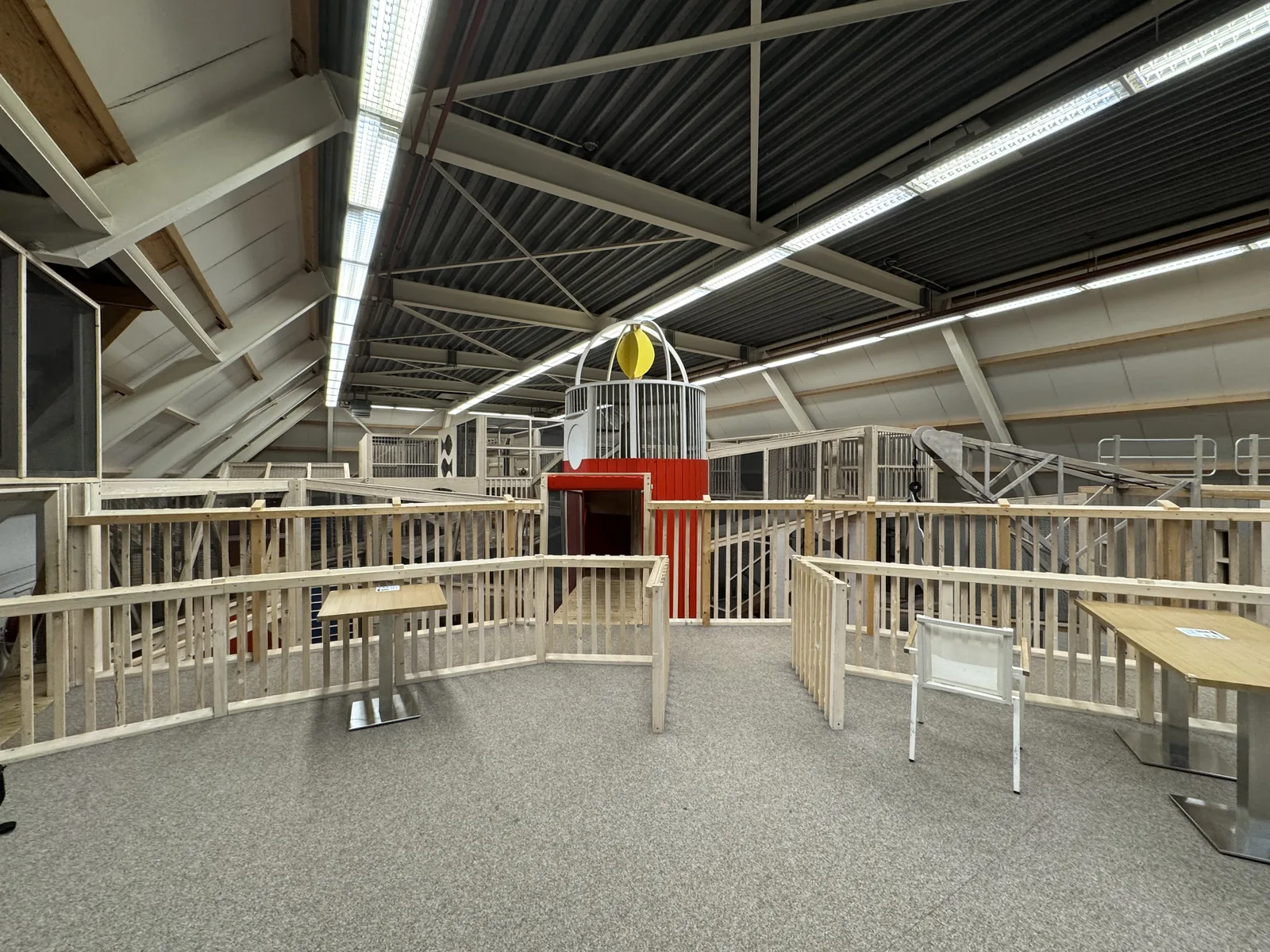 Große Indoor-Spielhalle im Ferienpark De Krim mit hölzernen Spielebenen, Geländern und einem roten Turm