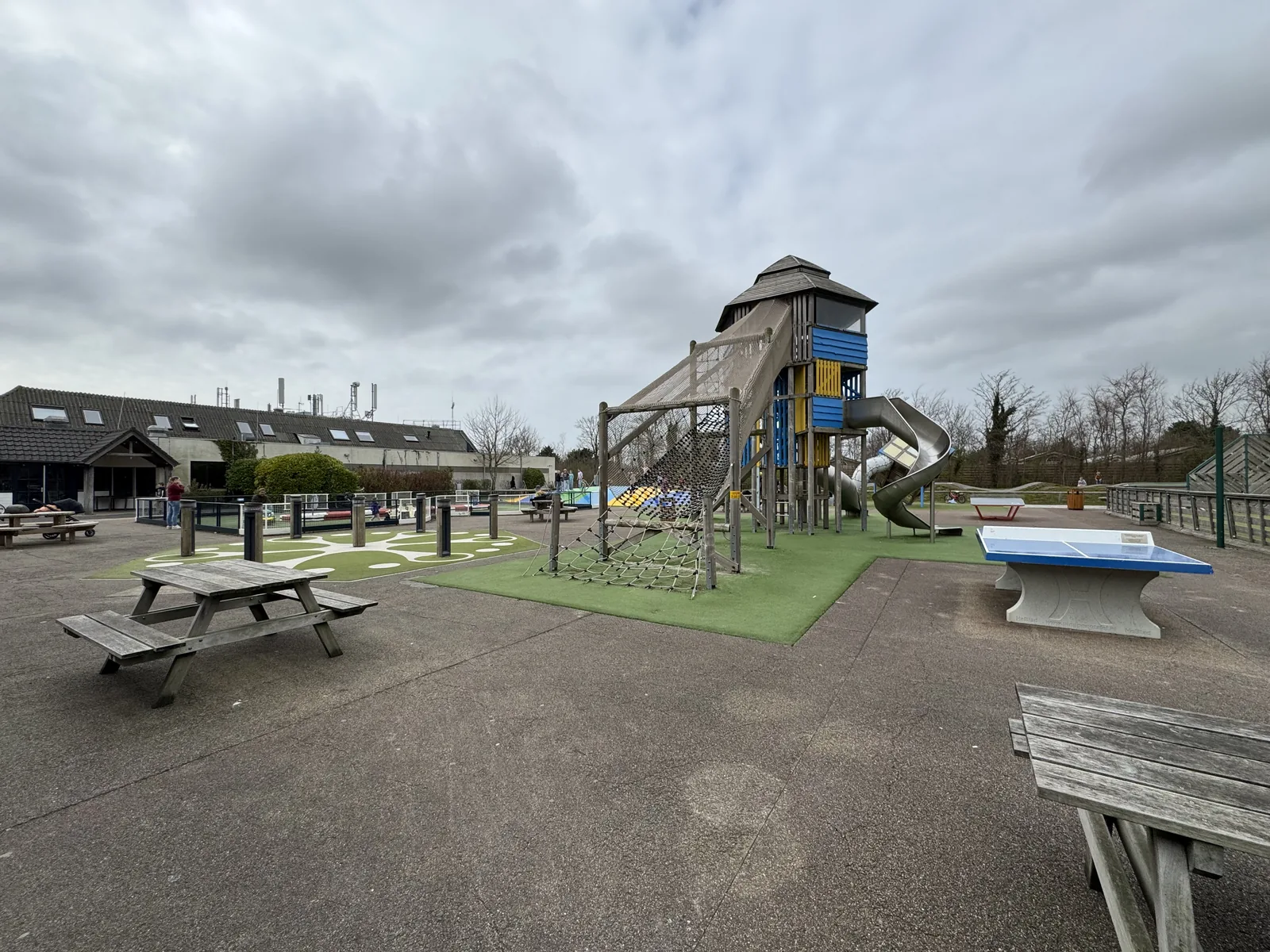 Großer Spielplatz im Ferienpark De Krim mit hölzernem Kletterturm samt Rutsche, Picknickbänken und Tischtennisplatte