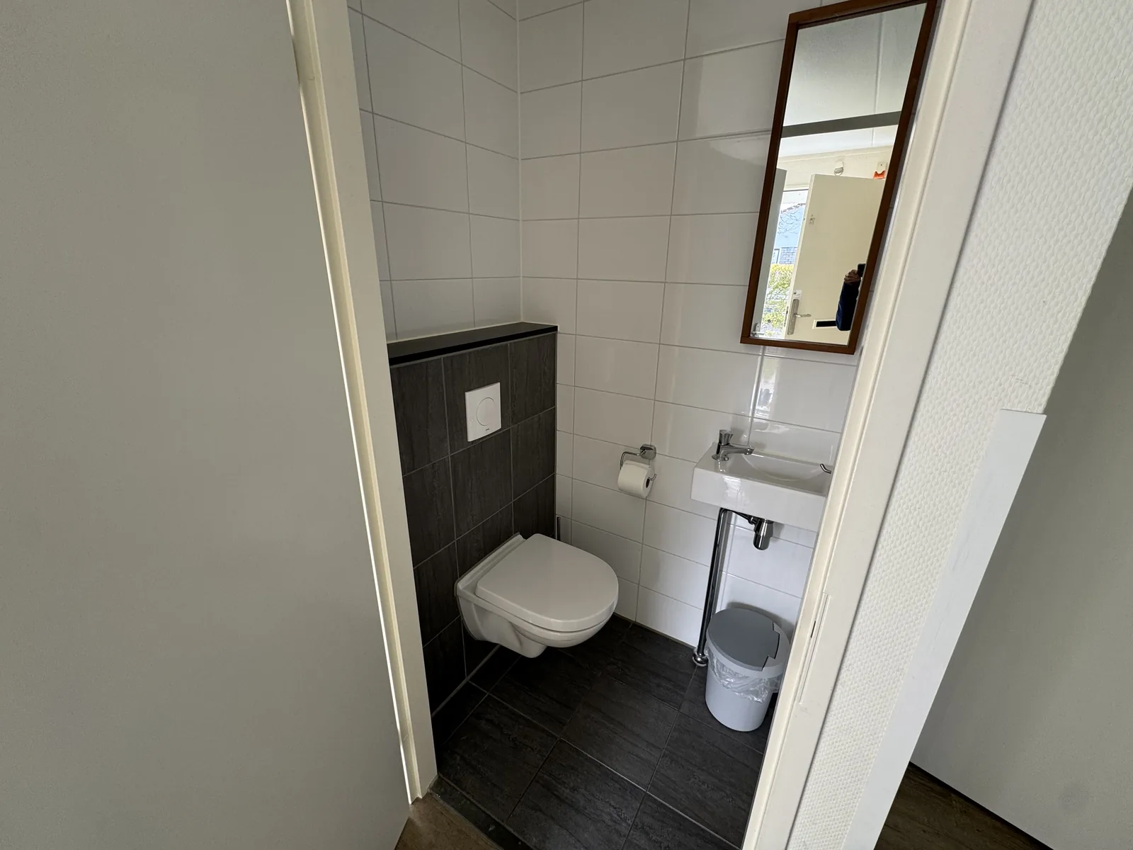 Schmales Gäste-WC mit Wand-WC, Waschbecken und Spiegel
