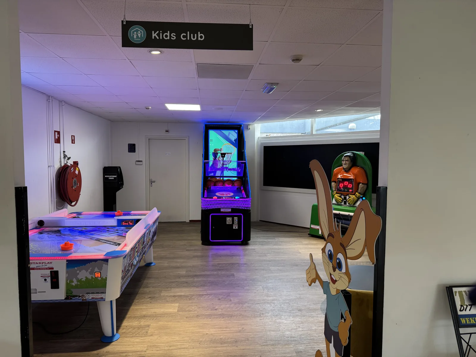 Kids-Club-Raum mit Airhockey-Tisch, Spielautomat und farbiger Beleuchtung