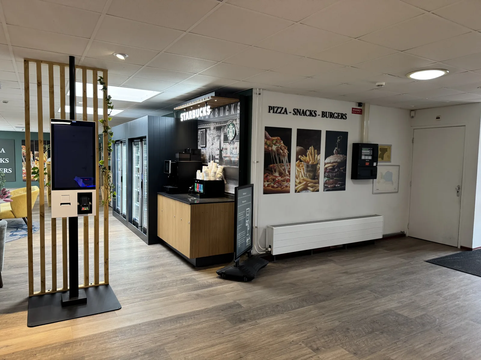 Innenraum der Snackbar im Kustpark Texel mit Theke, Bestellterminal und Werbetafel
